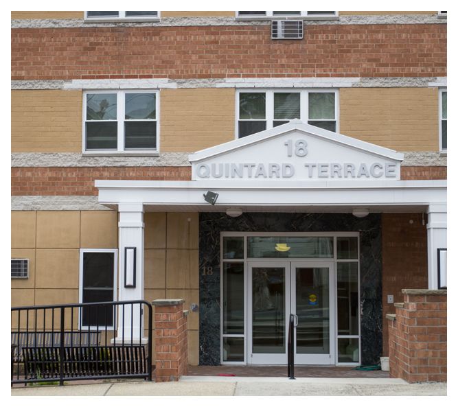 This close view of the entrance shows the marble facade around the double doors and the mix of brick in the building itself.