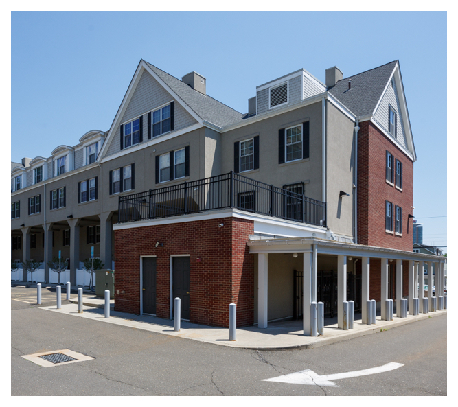 Taylor Street Apartments' contemporary exterior features concrete and brickwork; covered outdoor walkways line the building.