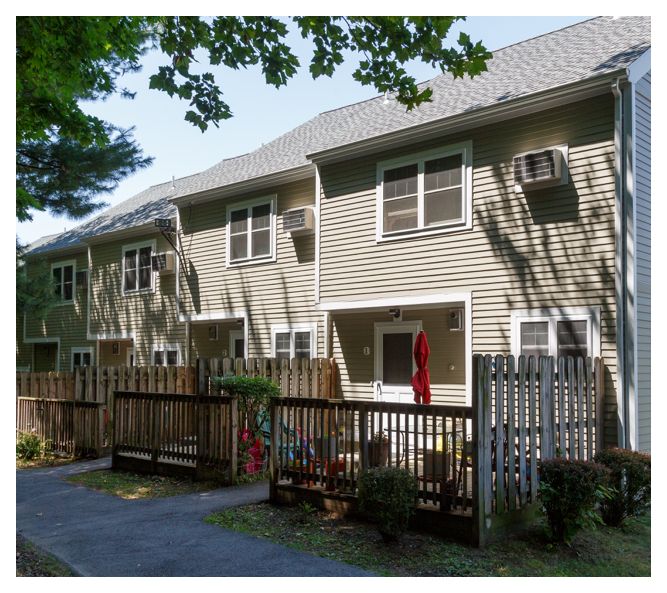 Ursula Park Townhouses feature multiple windows, in-wall AC units, and semi-private decks accommodating a small seating area.