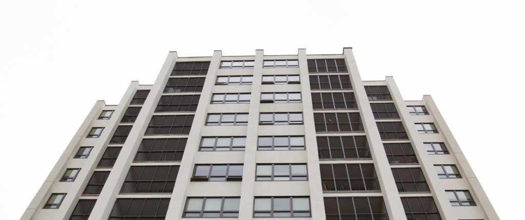 A view looking up at Clinton Manor, showcasing the many windows to let in natural light, some open to let in fresh air.