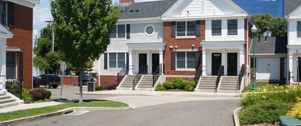 A wider view of the private, rear entrances showing a short series of stairs with beautiful black-metal railings.