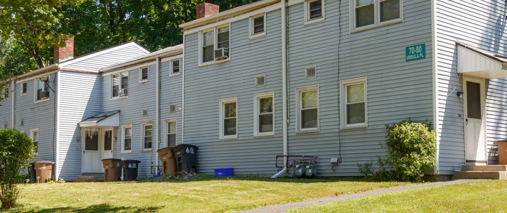 Surrounded by trees and natural light, the buildings look neat and tidy with some residents opting for window AC units.