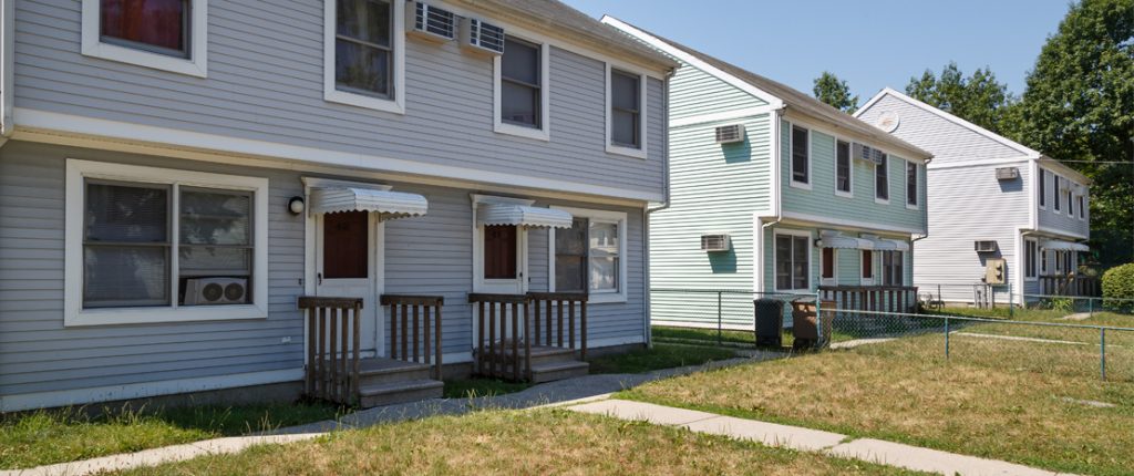 Three, two-story buildings feature operable windows, in-wall AC units, private, covered entrances and small front lawns.