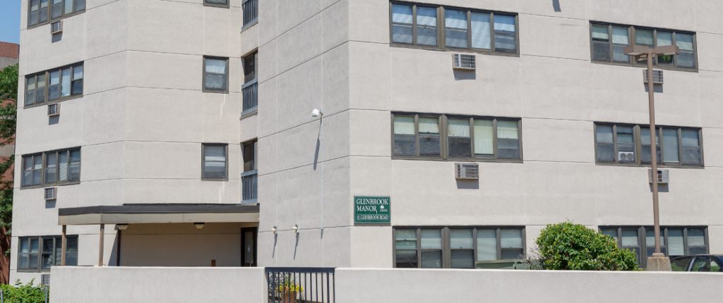 A horizontal view of the modern-looking apartment building with its many windows and exterior lights.